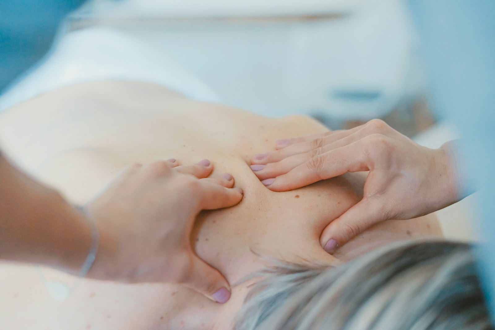 Therapist applying shiatsu pressure to a client's shoulders